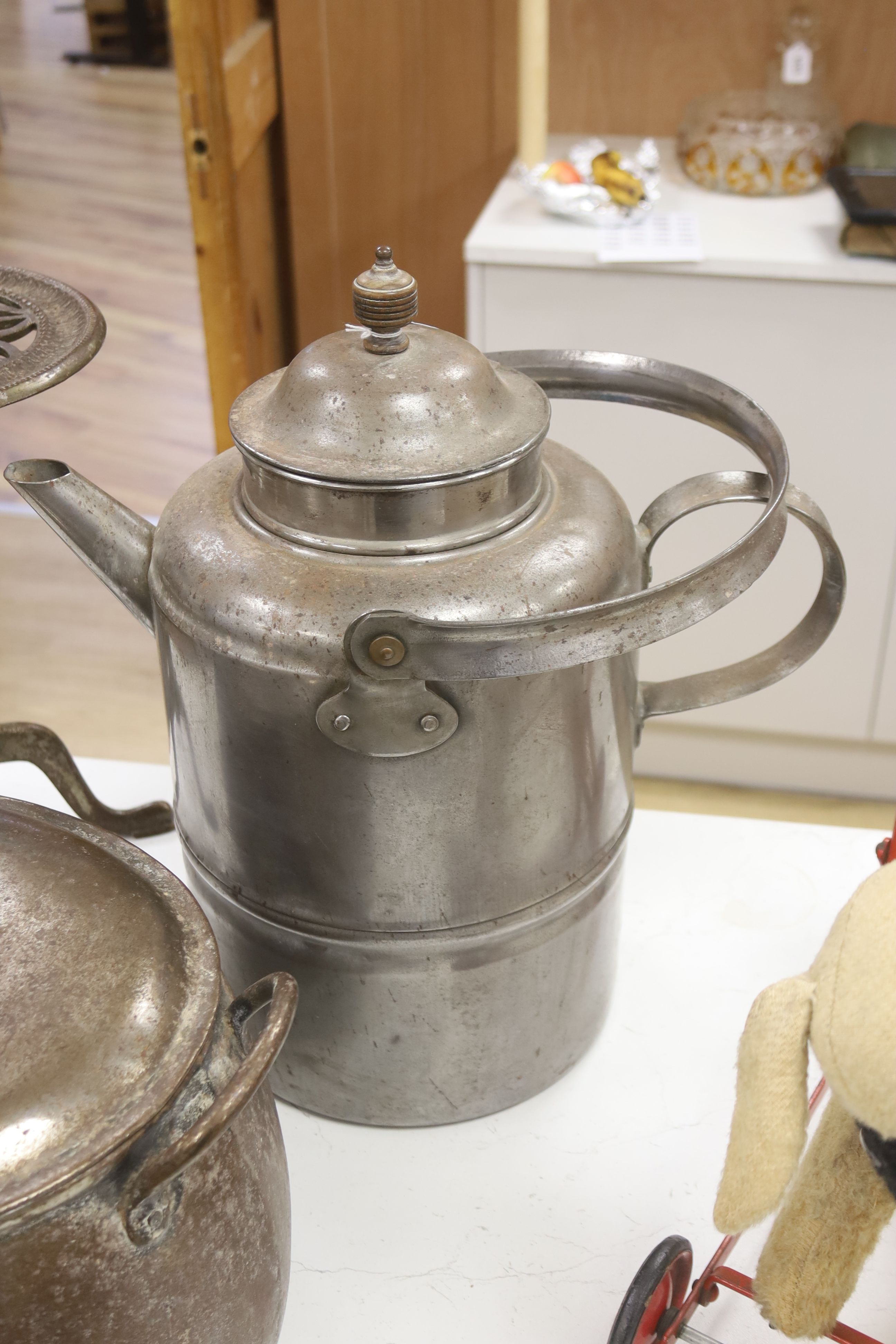 A metal trivet, a lidded pot and a kettle, tallest 43cm